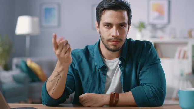 Serious Man Sitting at His Desk at Home Raises His Finger and Wags it, Warning not to Do Something Bad. 