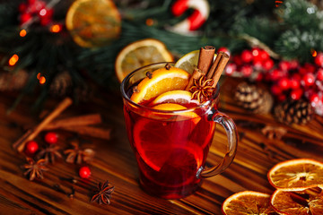 Fototapeta na wymiar Christmas mulled red wine with spices and fruits on a wooden rustic table. Traditional hot drink at winter time