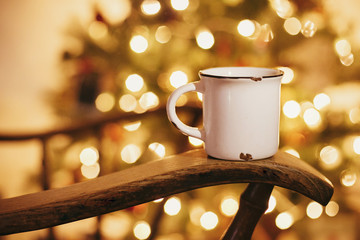 cozy winter holidays. warm atmospheric moment . mug with hot drink on old wooden chair on...