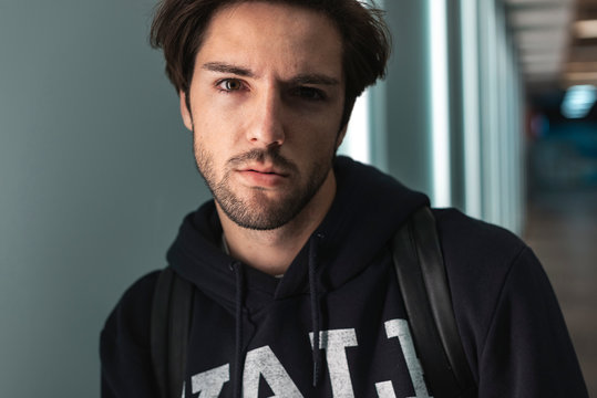 Close up portrait of handsome confident young man looking at camera wearing sweatshirt