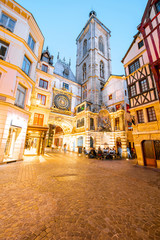 Street view with illuminated buildings and famous clock tower during the twilight in the old town of Rouen city in France
