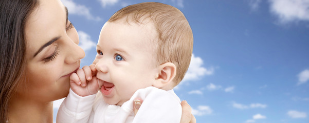 family and motherhood concept - happy smiling young mother with little baby over sky background