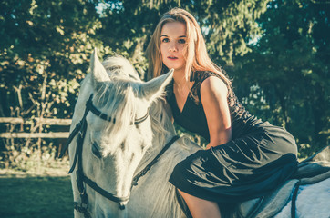 beautiful girl riding a horse in a long dress