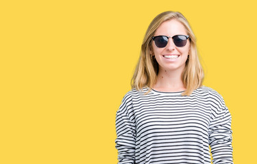 Beautiful young woman wearing sunglasses over isolated background with a happy and cool smile on face. Lucky person.