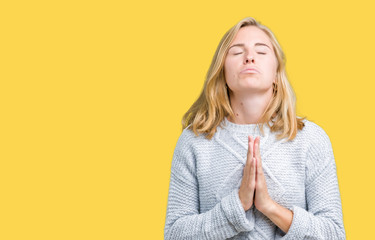 Beautiful young woman wearing winter sweater over isolated background begging and praying with...