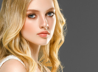 Blonde woman face closeup with healthy skin and beauty makeup