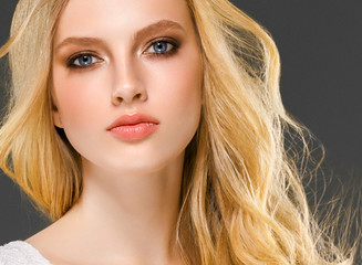 Blonde woman face closeup with healthy skin and beauty makeup