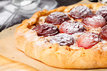 Plum pudding with tea and berries on blue vintage background.