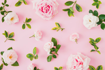 Composition with roses and leaves on pastel pink background. Flat lay, top view.