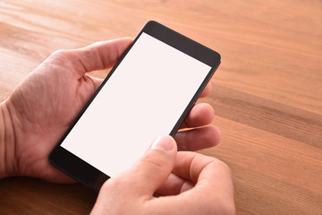 Hands with portable phone in hands on brown isolated table