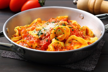 tortellini ripieni con salsa di pomodoro in tegame di metallo