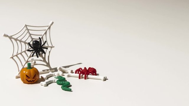 short animation, timelapse, with moving toys, for Halloween. With pumpkin, spider, cobweb, snake and bones. 4k video, 25 fps
