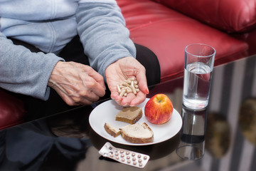 Senior bad life with no income concept. Old woman holding medical pills in hand