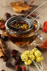 Herbal tea in transparent cups. Assorted herbs. Autumn still life. Cinnamon sticks. Wooden background