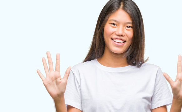 Young asian woman over isolated background showing and pointing up with fingers number ten while smiling confident and happy.