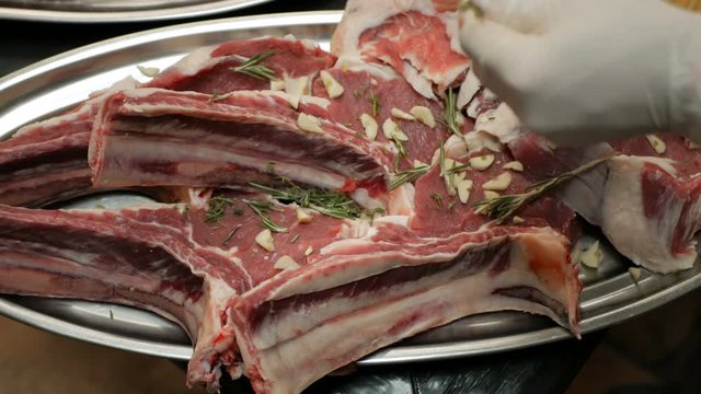 The chef of the restaurant marinates fresh beef