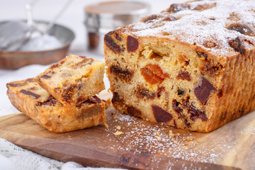 Traditional Christmas cake with fruits and nuts on white table