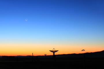 The silhouette of a radio telescope