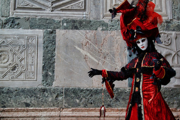 Fototapeta na wymiar Carnival red-black mask and costume at the traditional festival in Venice, Italy