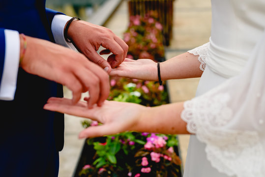 Newly-married couple stroking the palms of their hands.