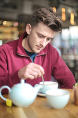 Fototapeta na wymiar Man sitting in a coffee shop, drinking a tea