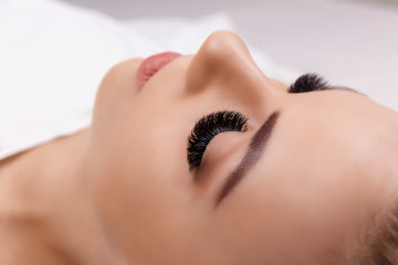 Eyelash Extension Procedure. Woman Eye with Long Eyelashes. Close up, selective focus. Hollywood, russian volume - 230405116