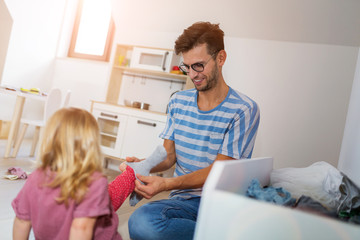 Obraz premium Father putting daughters socks on