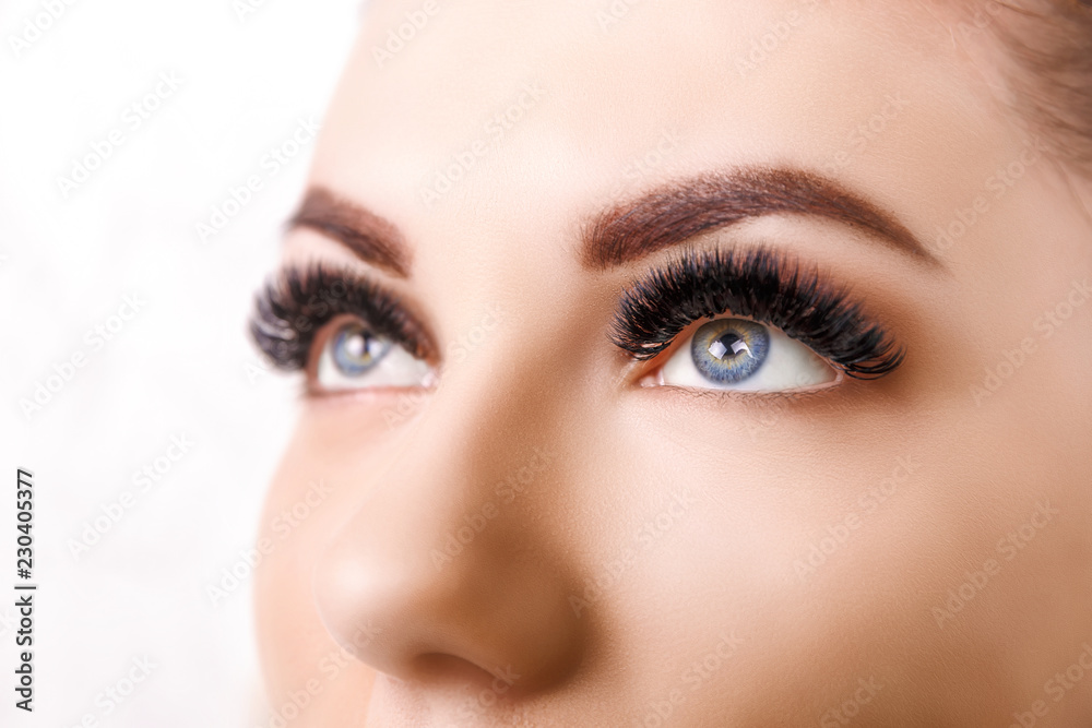 Wall mural Eyelash Extension Procedure. Woman Eye with Long Eyelashes. Close up, selective focus. Hollywood, russian volume