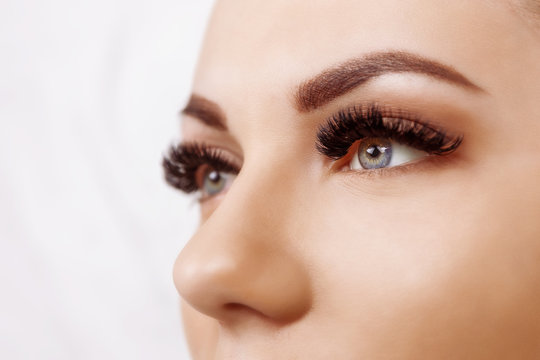 Eyelash Extension Procedure. Woman Eye with Long Eyelashes. Close up, selective focus. Hollywood, russian volume