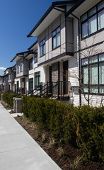 Brand new upscale townhomes in a Canadian neighbourhood. External facade of a row of colorful modern urban townhouses.brand new houses just after construction on real estate market