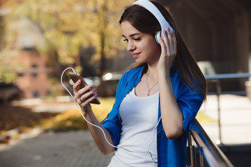 Fototapeta na wymiar Young woman listening to music with headphones in urban city