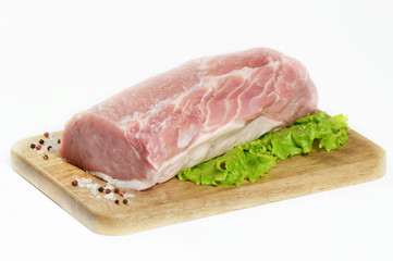 A piece of raw meat on a wooden board. A piece of pork carbonate for steaks. White background. Close-up. 