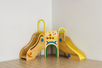 beautiful bright wooden slides in playing room at kindergarten