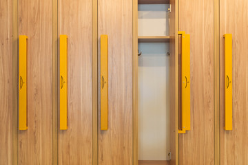 wooden lockers with yellow handles in kindergarten cloakroom