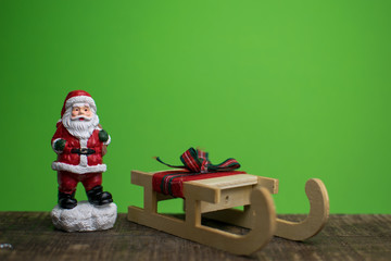 Close up of santa claus and a sled isolated on green backround