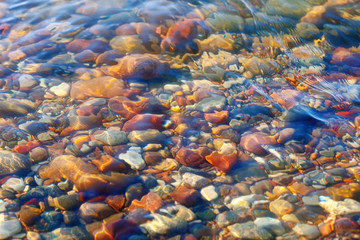 Fototapeta na wymiar Colorful stones under water. The concept of meditation, contemplation, peace and silence