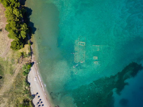 Aerial drone bird's eye view photo of tourists snorkeling above old Sunken City of Epidauros, Greece