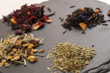 Close up of different mix of tea and dried fruits on white background