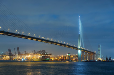 Cargo port and bridge in Victoria Harbor of Hong Kong city at night