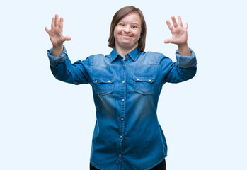 Young adult woman with down syndrome over isolated background showing and pointing up with fingers...