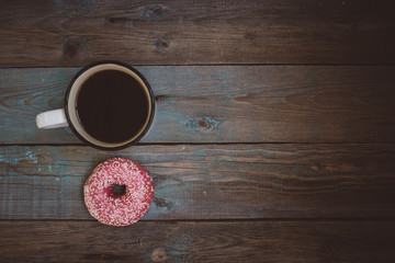 fresh donut with cup of coffee on the wooden table