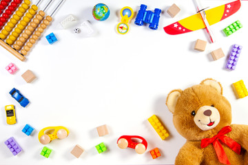 Colorful kids toys frame on white background. Top view. Flat lay.