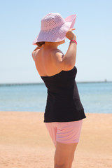girl in a hat with a beautiful sea background