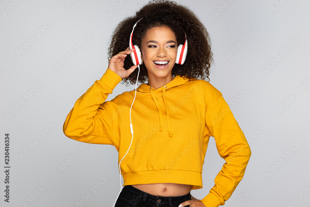 Wall mural Young woman enjoying music