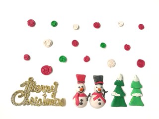 Cute snowman, tree and colorful spiral shaped are made from plasticine clay and merry Christmas glitter text on white background, beautiful wallpaper festival dough