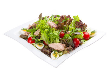 Salad with chicken breast and vegetables on a white plate