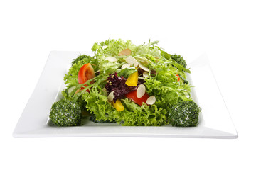 Salad with vegetables and cheese balls on a white plate