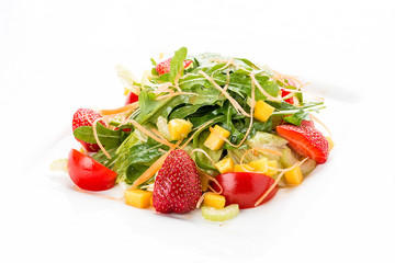 Summer salad with strawberries and tomatoes. On a white plate