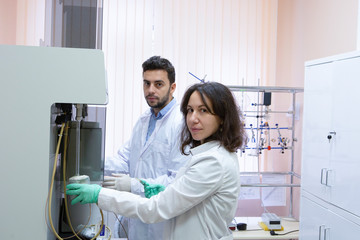 Obraz premium Female Research Scientist Uses Micropipette Filling Test Tubes in a Big Modern Laboratory.