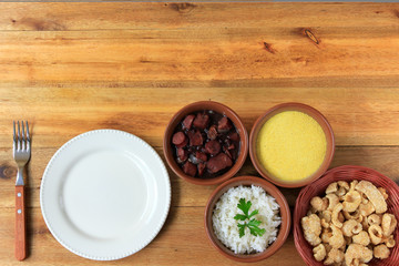 dish and fork next to feijoada, traditional brazilian culinary food top view